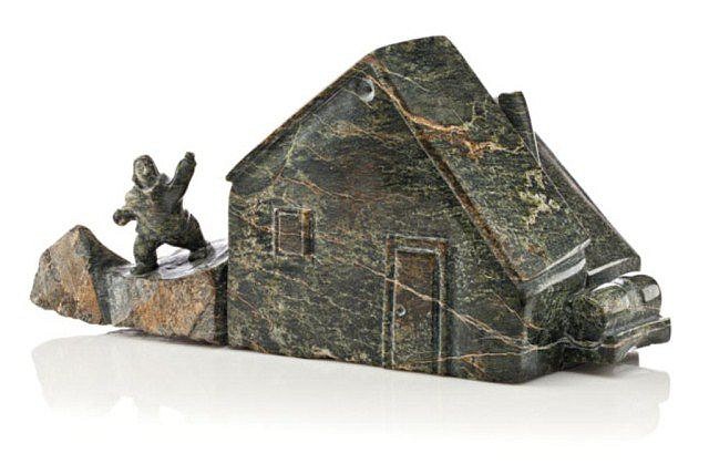 Napachie Sharky, Boy Standing Beside a House, 2002
Serpentine, 5 1/2 x 11 1/4 x 4 1/2 in. (14 x 28.6 x 11.4 cm)
SOLD
A new school of mostly young carvers has developed in Cape Dorset over the past decade or more.  Jamasie Pitseolak, Isacie Etidlooie and other talented artists are depicting everyday southern-style objects such as guitars, motorcycles and flowers by painstakingly constructing miniature stone replicas.  Napachie Sharky's house looks like it might have been inspired by a drawing of one of the new wave of Cape Dorset graphic artists.
01626-1