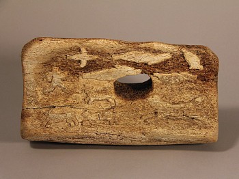 Work:&nbsp;Whalebone block with low relief carvings of seals, birds, dogs and man on a komatik