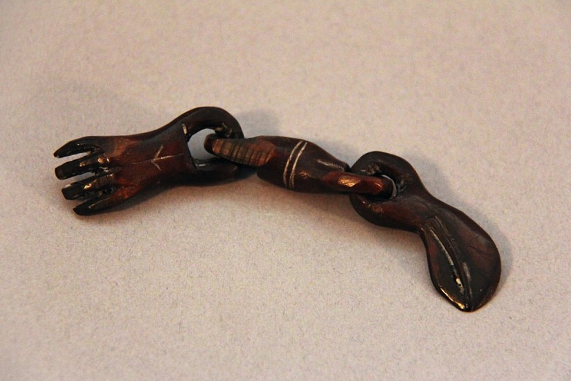 OBS Anonymous, Hand and whale on chain, Ipiutaq
ivory, 4 x 1/2 x 1/2 in. (10.2 x 1.3 x 1.3 cm)
NOT FOR SALE. An amulet in the form of a human hand is joined to an amulet in the form of a whale's head by a single link.  There is an incised star on the back of the hand.  All parts have a uniform, deep brown patina.  See Wardwell, Ancient Eskimo Ivories of the Bering Strait (1986), plate 154 for a similar object.  Wardwell writes, 'The Ipiutak created a wide variety of animal figures, including polar bear, walrus, seal and bird forms,as well as chains and the openwork spiral carvings unique to them.  Although no pure representations of the human figure are known, a few sculptures combine human and animal forms.'
01215-1