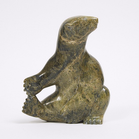 Inuit Anonymous, Seated polar bear
8 x 6 1/2 x 3 in.
This whimsical sitting bear is testimony of the artist's determination to find a bear in a broad but thin piece of stone. The head has a particularly sweet expression, and the paws are decisively sculpted. There is an indistinct signature, followed by "Inuvik, NWT."